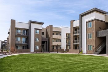 Apartment complex with a green lawn in front.